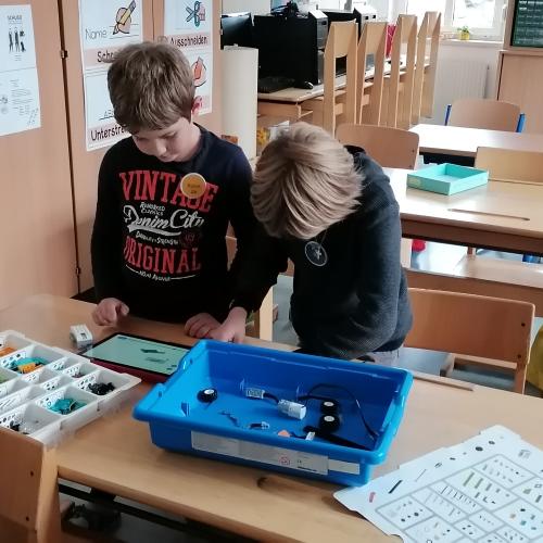 Kinder bauen aus Lego einen Roboter