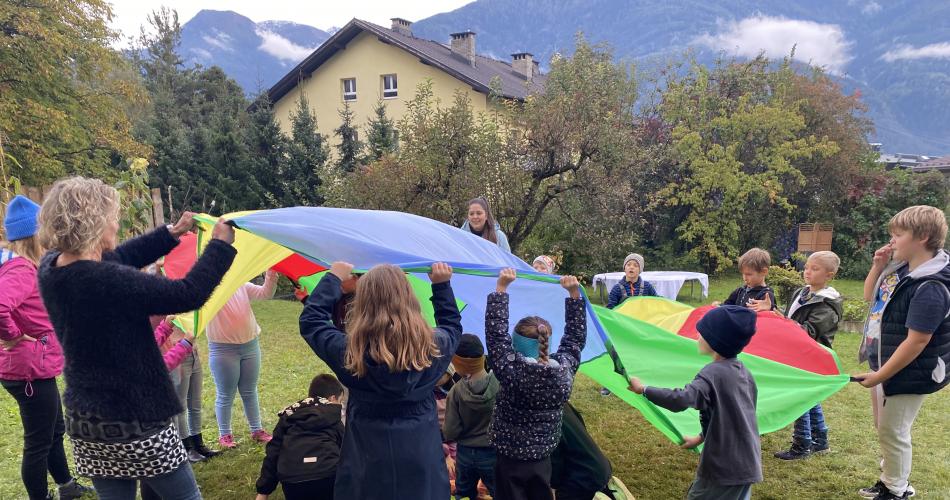 Kinder spielen mit einem Schwungtuch.