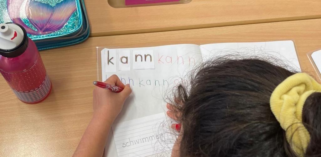 Wortzauberei 1 Mädchen von hinten, schreibt in ein Heft