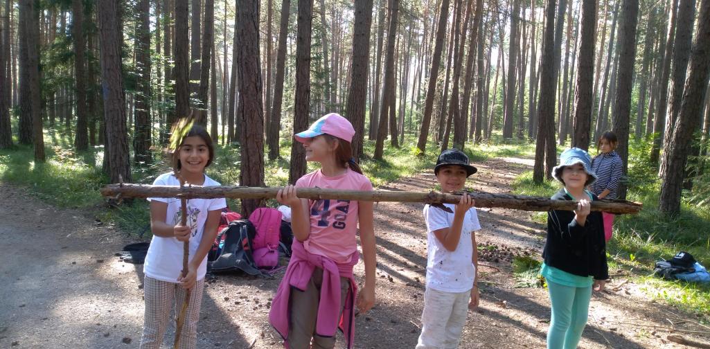 20/21 Wandertag 4 4 Kinder tragen gemeinsam einen langen Ast