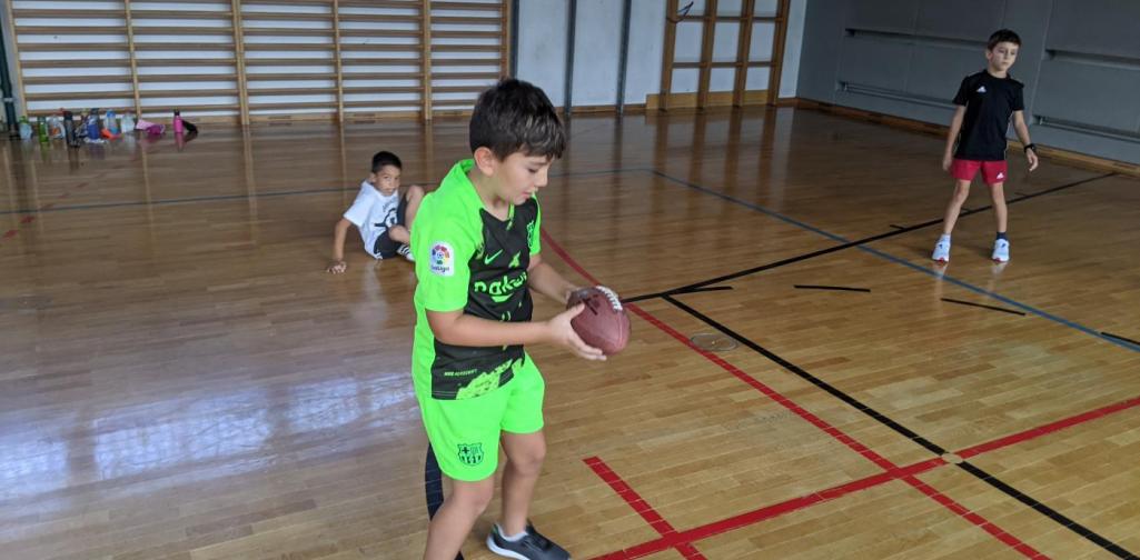 Einzelfoto Flag Football Kind der 3a Klasse mit einem Football in der Hand