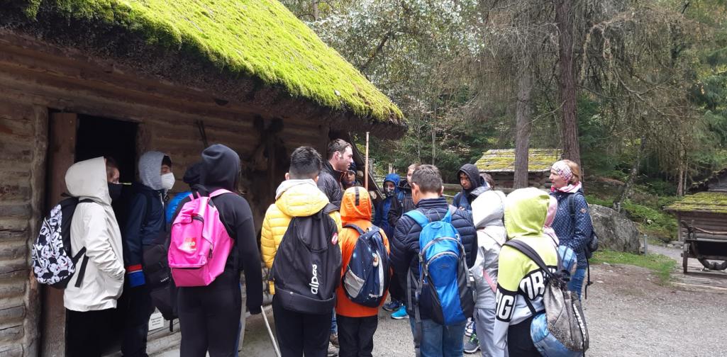 Klasse vor einer steinzeitlichen Hütte