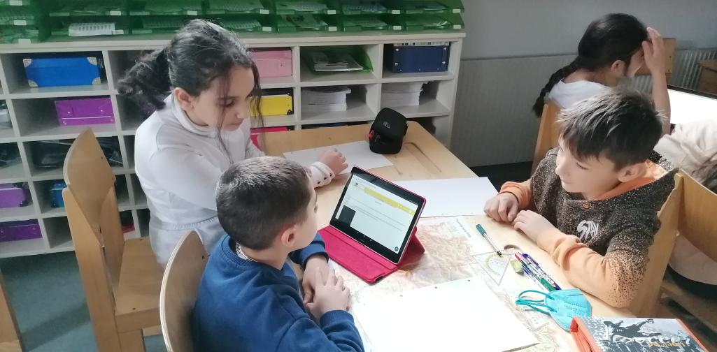 Gruppenarbeit mit Tablet und Landkarte