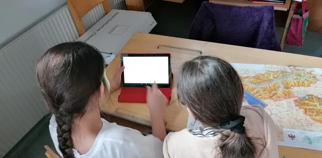 Kinder arbeiten mit Tablet und Landkarte