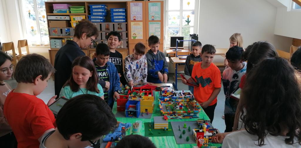 Kinder und eine Lehrerin sehen sich das Modell an