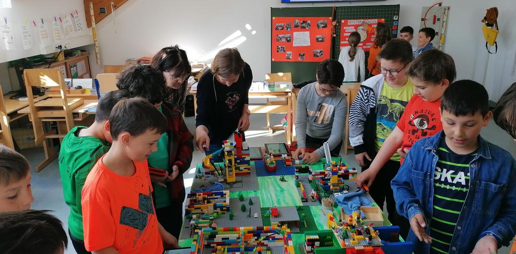 KInder und zwei Lehrerinnen sehen sich das Modell an