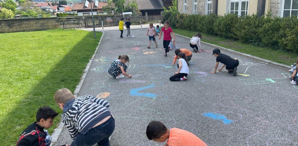 Kinder malen mit Straßenkreiden Figuren