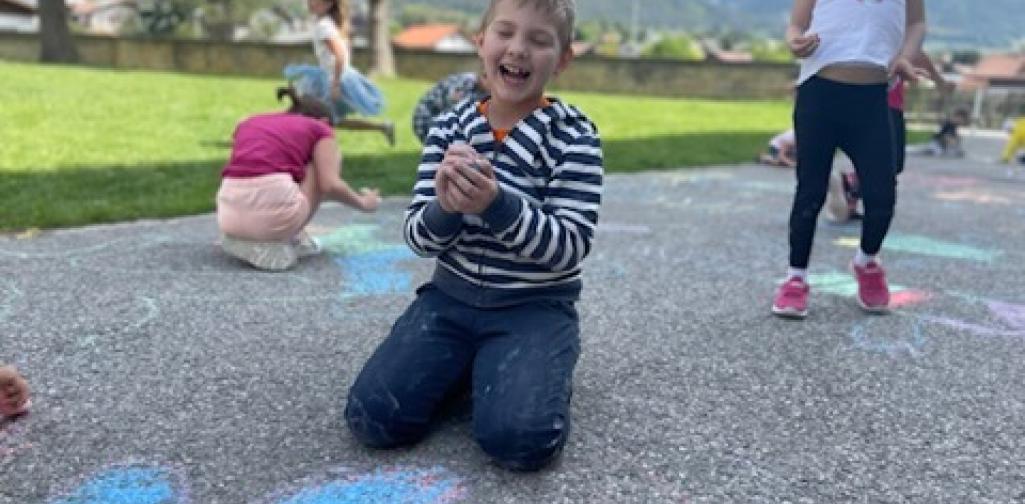 Kinder malen mit Straßenkreiden Figuren