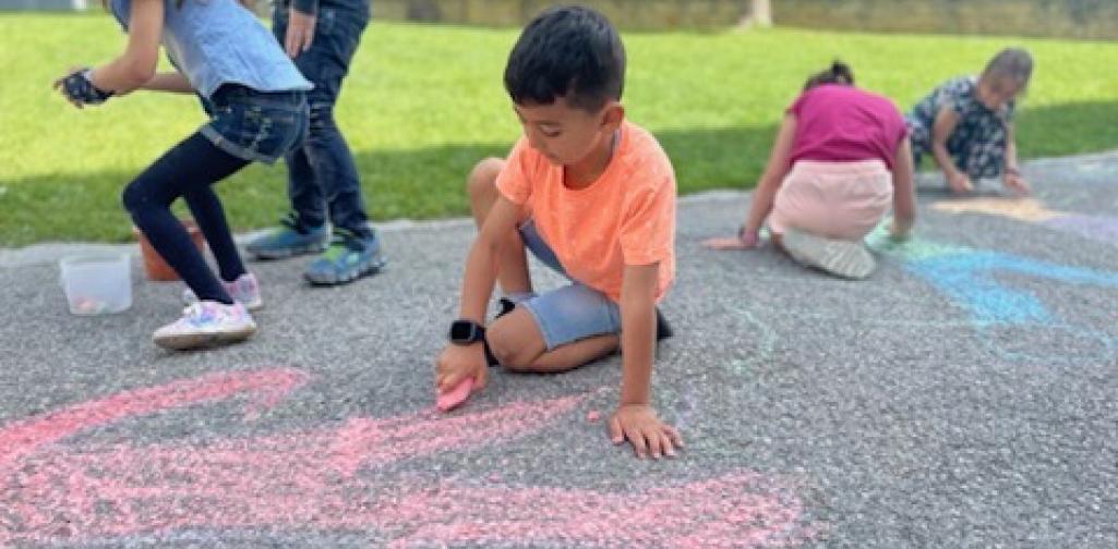 Kinder malen mit Straßenkreiden Figuren