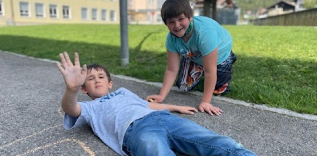 Kinder malen mit Straßenkreiden Figuren