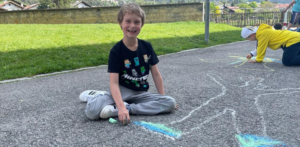 Kinder malen mit Straßenkreiden Figuren