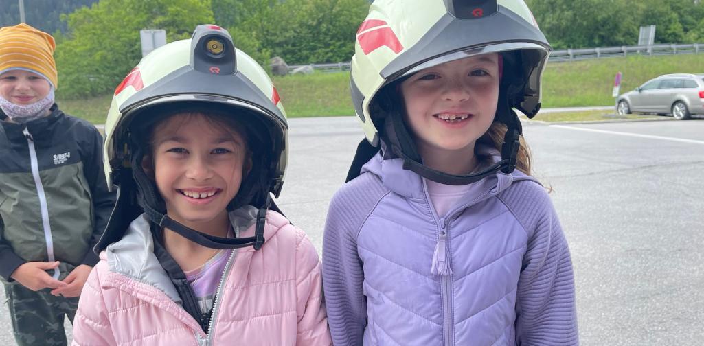 Kinder tragen einen Feuerwehrhelm