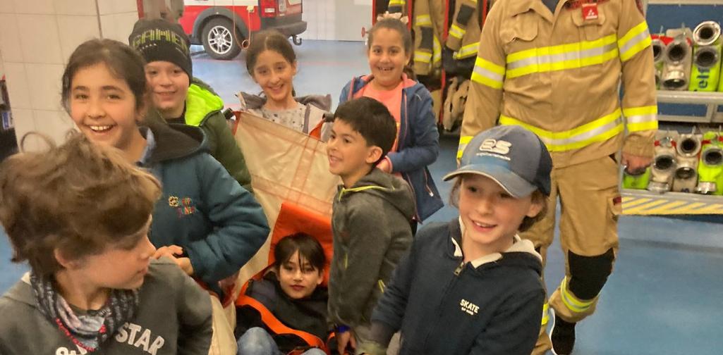 ein Kind wird von anderen Kindern auf einer Trage getragen