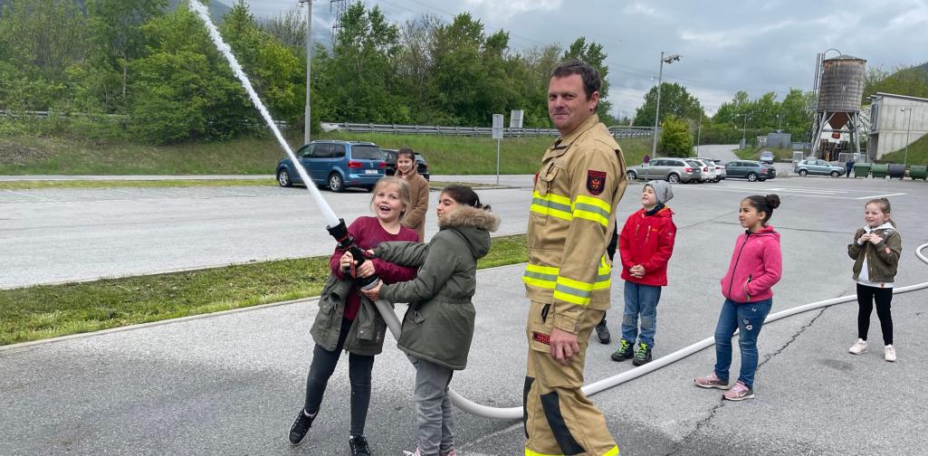 Kinder probieren den Löschschlauch aus