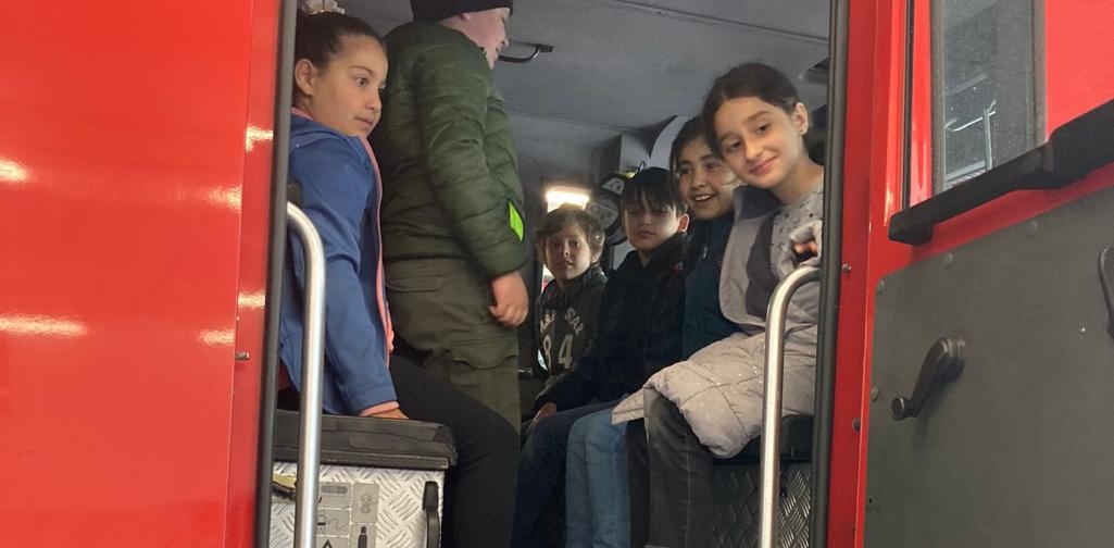 Kinder sitzen im Feuerwehrauto