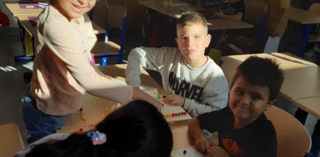 Kinder stekcne den Buchstaben mit Steckperlen nach