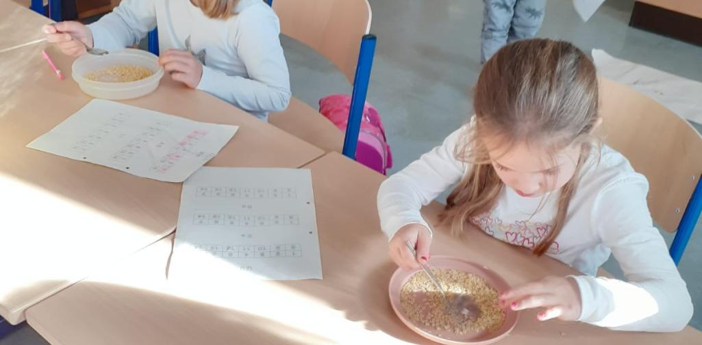 Kinder suchen die Buchstaben in einer Buchstabensuppe
