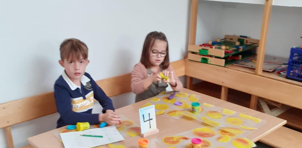 Kinder formen den Buchstaben aus Knetmasse