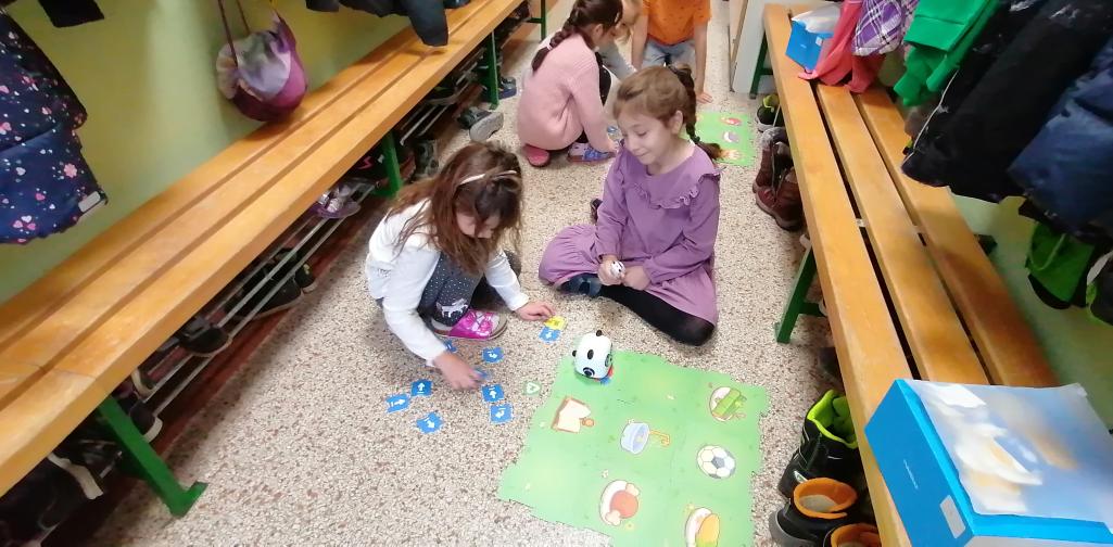Kinder lassen den TinyRobot auf dem Spielfeld fahren