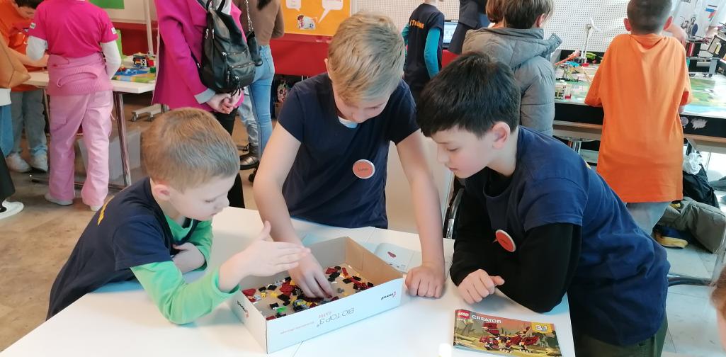 FLL 3 Kinder bauen gemeinsam an einer Legofigur