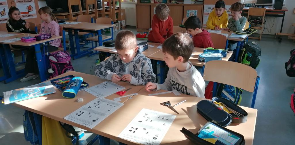 digitale Grundbildung 5 Kinder arbeiten konzentriert in Partnerarbeit