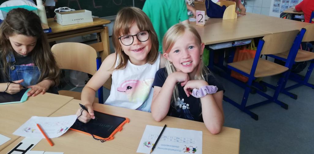 Schulkinder und Kindergartenkinder arbeiten gemeinsam an den Stationen