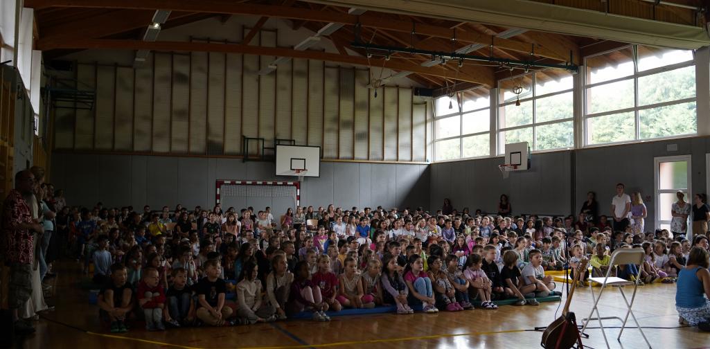 Abschlussfeier 02 Kinder sitzen gemeinsam im Turnsaal