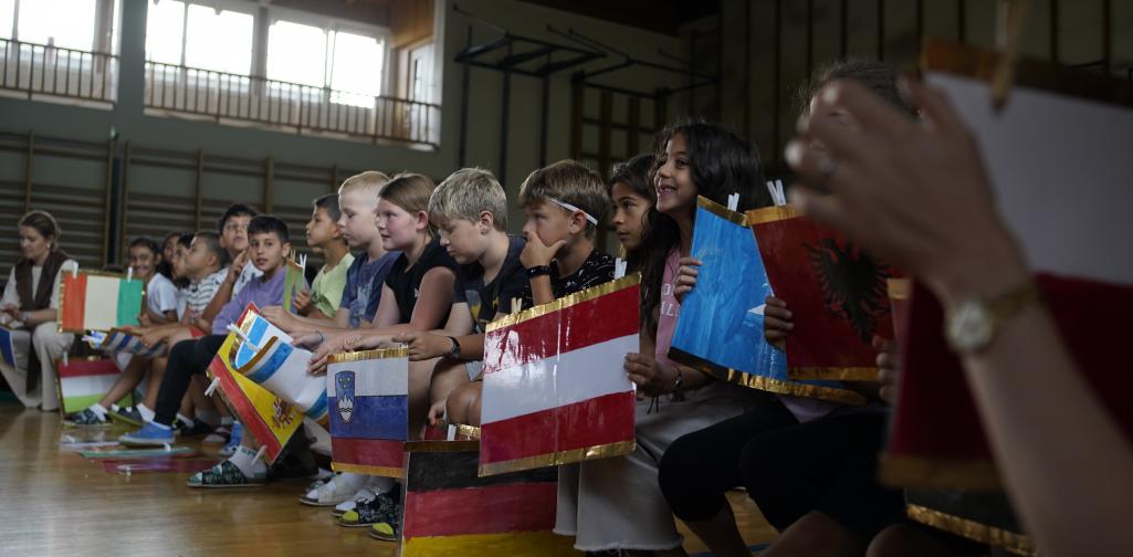 Abschlussfeier 05 Kinder halten verschiedene Fahnen in den Händen