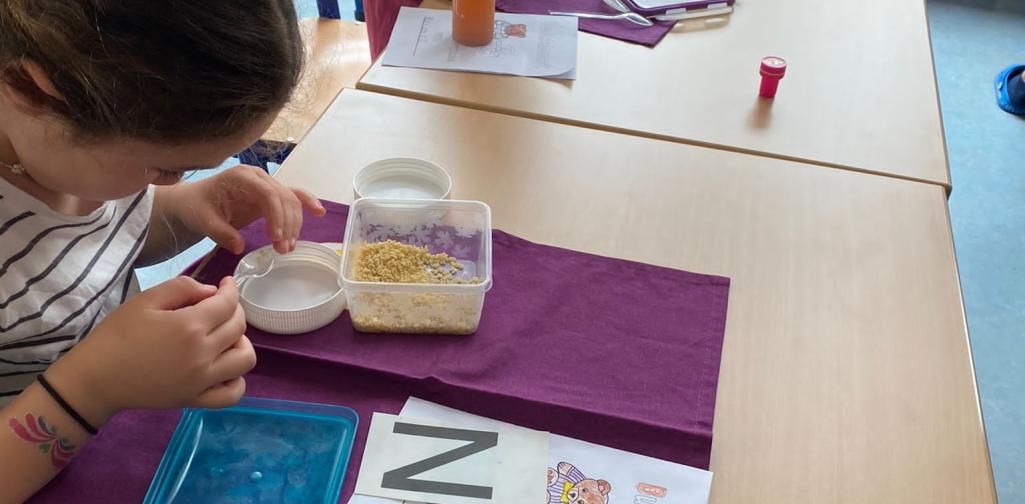 Kinder suchen Buchstaben in einer Nudelsuppe