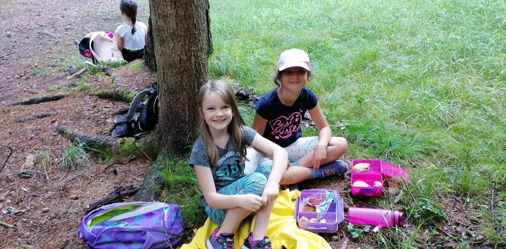 Wandertag 7 Kinder beim Jausnen im Wald