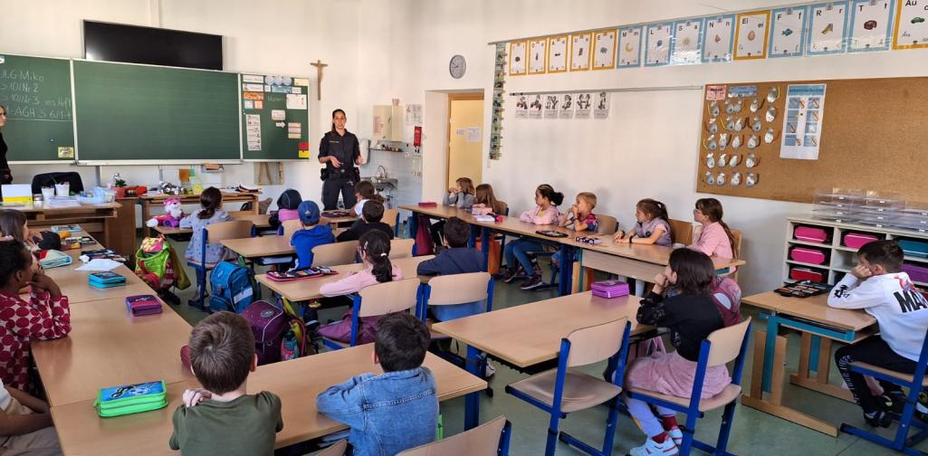 Polizei 2 Kinder erhalten in der Klasse eine Einführung durch die Polizistin