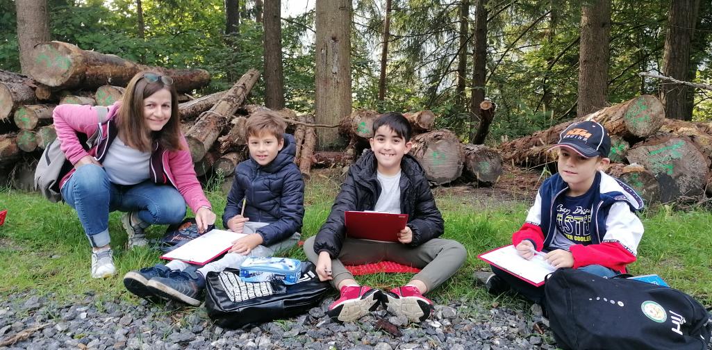 Schule im Wald 8 Kindergruppe erldigt Schulaufgaben im Wald mit Lehrerin