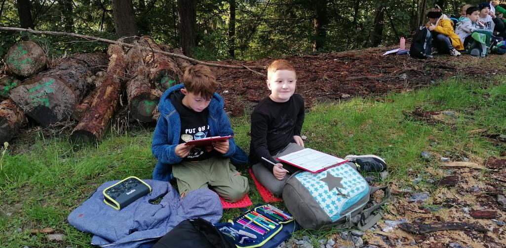 Schule im Wald 7 zwei Schüler arbeiten an ihren Schulaufgaben