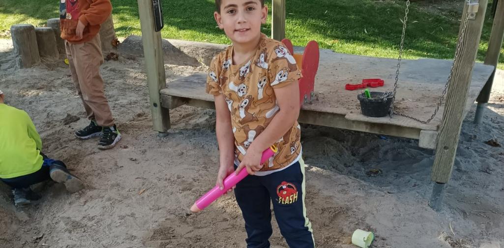 Kind präsentiert ein Bild in der Sandkiste