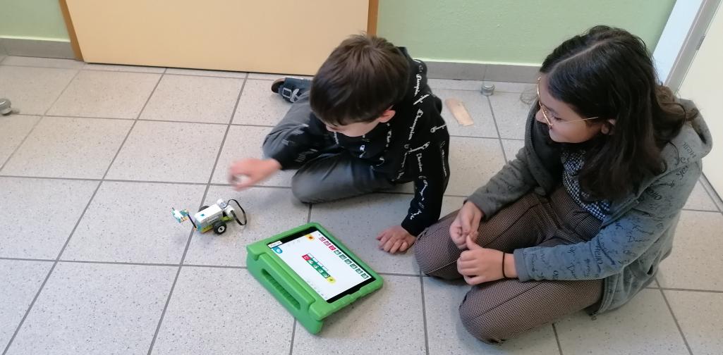 Roboter 13 zwei Kinder programmieren einen Roboter mit Klemmbausteinen