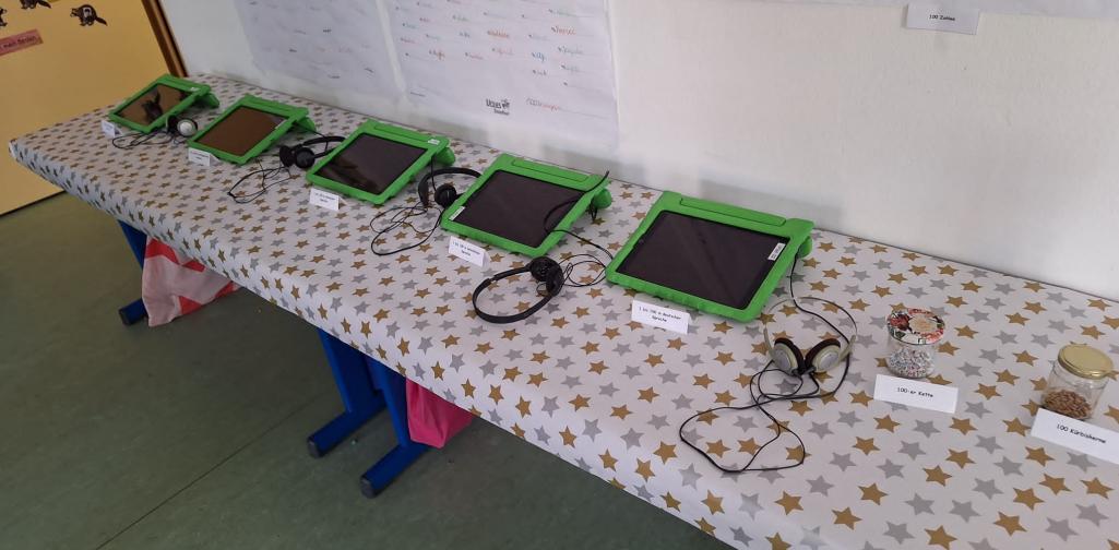 Hunderterfest 02 Ausstellungstisch mit Tablets und Gläsern (Inhalt immer 100)