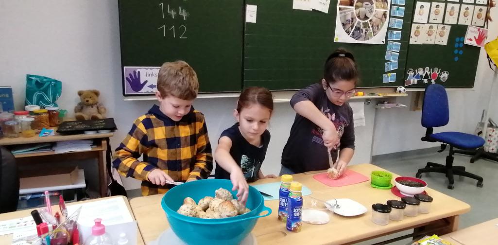 Milch 07 drei Kinder streichen sich ein Butterbrot
