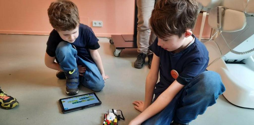 FLL 05 zwei Kinder stellen ein Auto aus Legosteinen vor