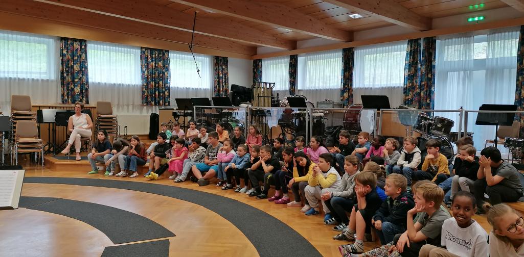 Instrumentenkompott 1 Kinder sitzen im Probenraum und hören zu