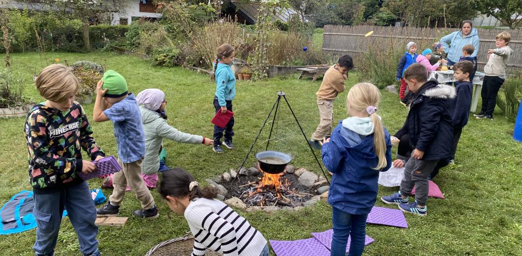 Kinder befinden sich im Garten der Naturpädagogin.