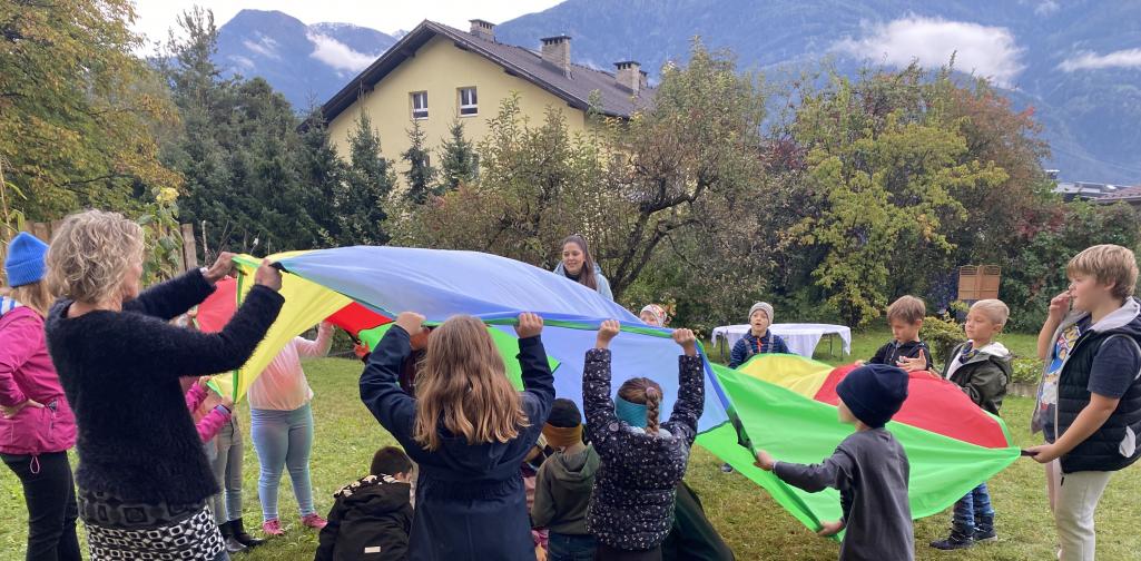 Kinder spielen mit einem Schwungtuch.