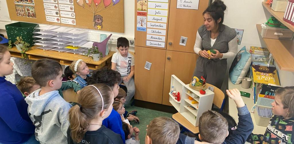 Kinder stehen um einen kleinen Kühlschrank