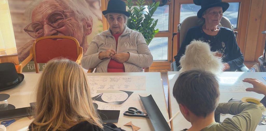 Kinder und Bewohner:innen des Altenheimes beim Basteln