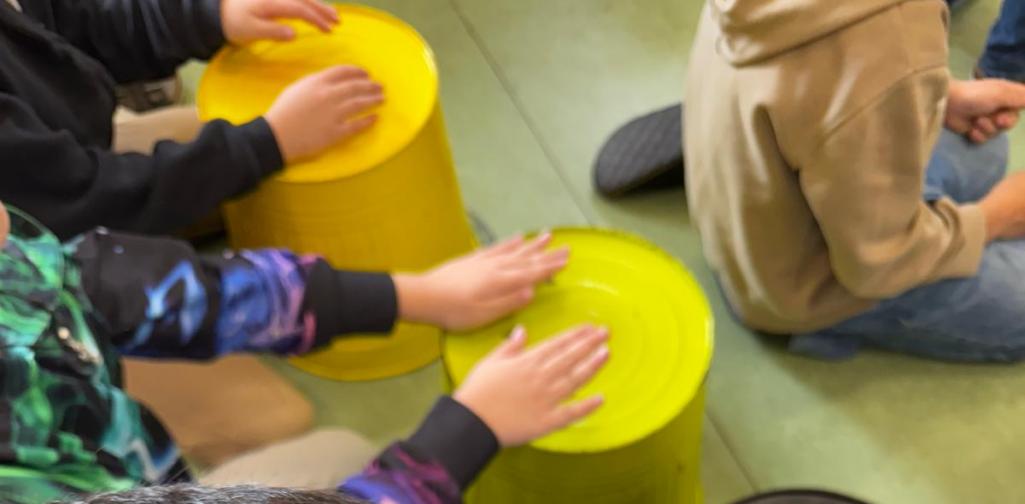 Kinder trommeln auf Kübeln