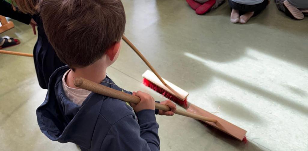 Kinder halten Besen in der Hand