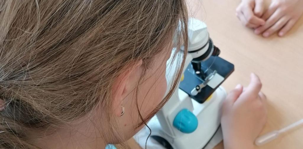 Kind beim Mikroskopieren