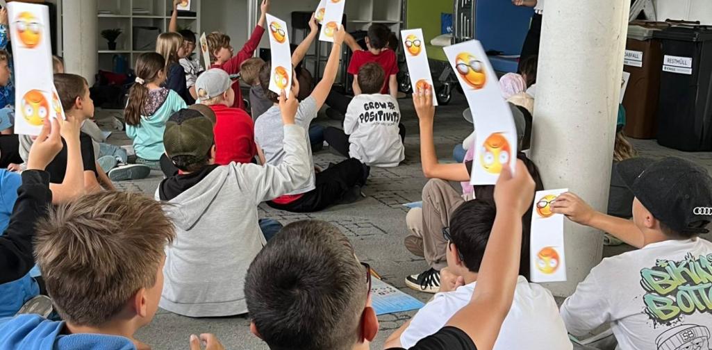 Kinder halten Kärtchen hoch