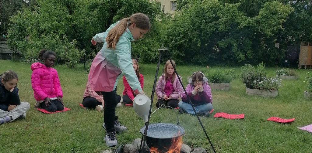 Bild 05 Kessel über dem Lagerfeuer wird mit Wasser gefüllt