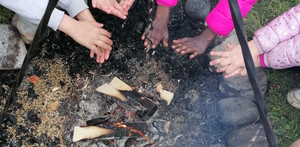 Bild 04 Kinder wärmen sich am Lagerfeuer die Hände