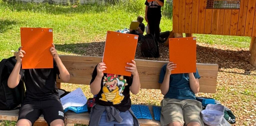 Kinder sitzen auf einer Bank